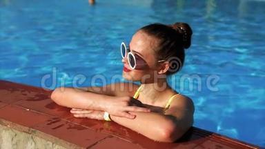 一个夏天，在甲板椅上晒日光浴后，成年女孩正在游泳池里降温