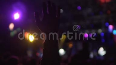 男子手在黑暗中挥动在音乐会上，观众享受精彩的表演，慢节奏
