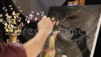 在艺术工作室的画布上，拉近人`手画的静物画面