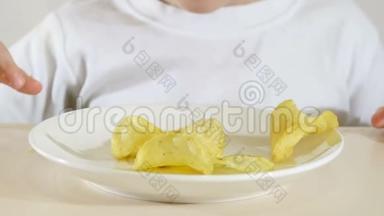 一个孩子正在吃薯片，坐在一张白色背景的桌子上，特写。