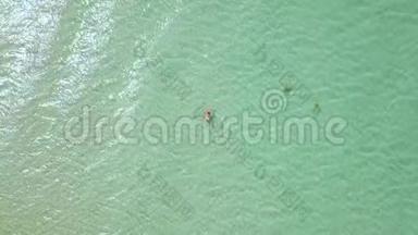女子游泳在晶莹剔透的海水无人机视野.. 在天堂海滩的鸟瞰中，女人沐浴在绿松石的海水中