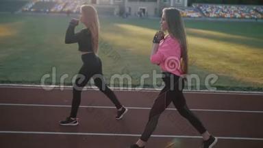 两个漂亮的体育女孩，在体育场的火车上<strong>身材</strong>很<strong>好</strong>。 女孩在日落时训练