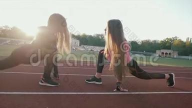 两个漂亮的体育女孩，在体育场的火车上<strong>身材</strong>很<strong>好</strong>。 女孩在日落时训练