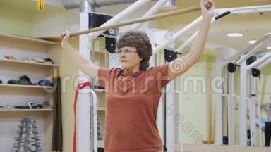 老年妇女提棍，在健身室做理疗练习。 健康体操。 活跃的老年人。