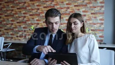 商人在平板电脑上向商人展示一些东西。