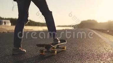 日落时分，女孩在一条荒芜的公路上的滑板上滑冰。 青年亚文化。 后景。 慢动作