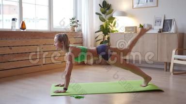 年轻女子在家锻炼。 高加索女人在瑜伽垫上做体重运动