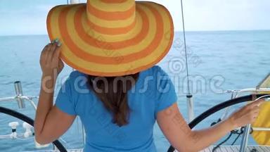 穿着黄色帽子和<strong>蓝色</strong>裙子的女人站在游艇<strong>上</strong>，在海洋的<strong>夏季</strong>微笑