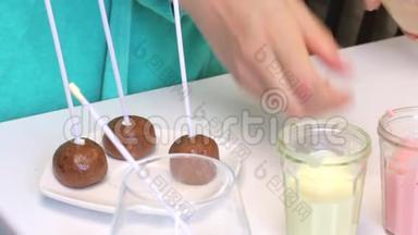 用棍子筷子做流行蛋糕的饼干球躺在盘子里。 桌子附近有带糖霜的眼镜。