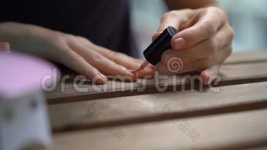 一位女士用在紫外线下变硬的凝胶抛光来修指甲