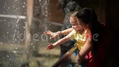妈妈和可爱的女儿玩小瀑布。 他们在母亲节一起玩得很开心。
