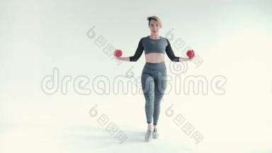 体操用球的运动女孩。 强壮的年轻女孩在灰色背景上训练肌肉的照片。 实力