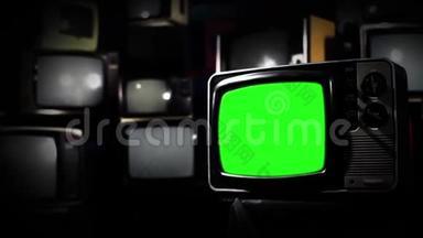 复古电视在许多电视中间打开绿色屏幕。 80年代的美学。