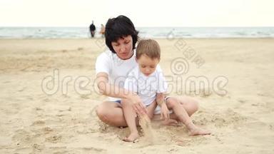 快乐的妈妈和她的孩子在<strong>海边玩沙子</strong>，动作很慢。