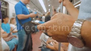 <strong>地铁</strong>列车<strong>上</strong>的人在智能手机<strong>上</strong>通过社交媒体读取信息。 慢动作视频。 乘客
