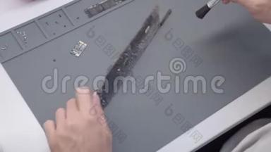 工程师修理损坏的笔记本电脑。 工程师提取笔记本电脑的纸板