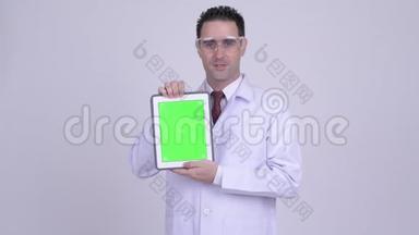 戴着数码平板电脑的防护眼镜的快乐帅哥医生
