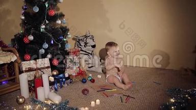 快乐的<strong>小男孩</strong>靠近一棵漂亮的圣诞树。 那孩子又玩又笑。 良好的<strong>新年</strong>精神