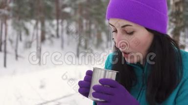 冬天，一个女孩在大自然中喝热水