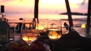 夫妻俩手里拿着两杯白葡萄<strong>酒</strong>，对着大海的夕阳。 慢动作，1920x1080