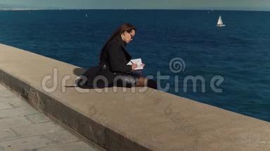女人在海边的户外<strong>素描</strong>书上画<strong>素描</strong>。 慢镜头