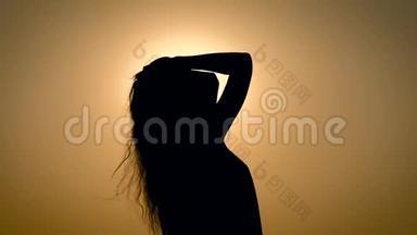 在天空中夕阳的<strong>背景</strong>下，匿名的女人颤抖着头发。
