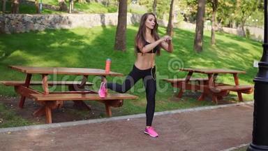 <strong>健身</strong>女孩在夏天在公园里用长凳做午<strong>餐</strong>，听着耳机里的音乐。 工作安排