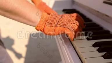<strong>钢琴</strong>演奏者手的特写，手套在键盘上演奏。 男人`<strong>钢琴</strong>键盘上戴手套的手