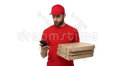 送货男孩穿着红色制服，拿着一叠比萨饼盒，在<strong>手机</strong>上检查<strong>订单</strong>。 孤立于白色之上
