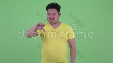 身材矮小、体重超重的亚洲年轻人竖起大拇指