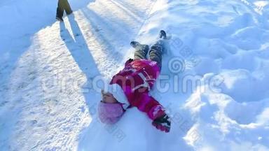 躺在雪地上的小女孩。 免费儿童在雪地里玩耍