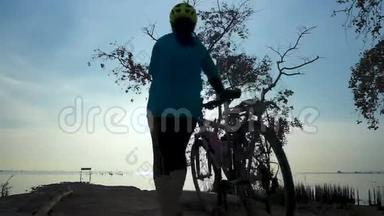 骑自行车的女<strong>人</strong>在海边骑自行车<strong>走路</strong>的<strong>剪影</strong>，伸展运动。