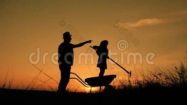 父亲和女儿的剪影与土地运输和耙子工具。小规模有机农业