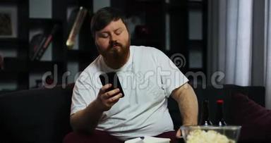 胖子看电视，在他的智能手机里打字。 他点了<strong>家常菜</strong>。 营养不良、食物的概念