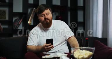 胖子看电视，在他的智能手机里打字。 他点了家常菜。 营养不良、食物的概念