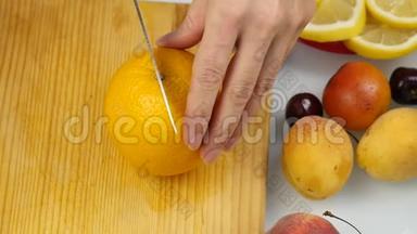 漂亮的女人在切割板上切新<strong>鲜</strong>的橙色水果做沙拉或<strong>榨汁</strong>。 减肥和节食的概念.. 慢慢慢慢