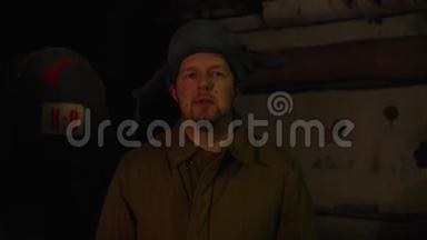 俄罗斯男人戴着一顶带耳罩的帽子，在黑暗的<strong>地下室</strong>里打电话，决定国家大事。