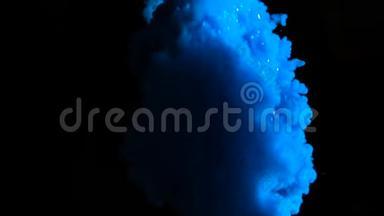 真正的蓝色油漆滴在水中缓慢的运动。 墨水在水下旋转。 黑色上孤立的墨迹碰撞
