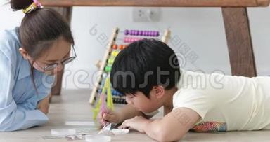 亚洲青少年男孩和他的妹妹一起在家<strong>做手工</strong>，带着微笑的脸。