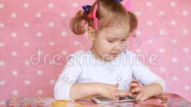 孩子玩手机.. 一个漂亮的小女孩用智能手机玩游戏
