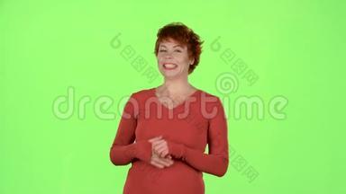 红发女人谈论商品的优点。 绿色屏幕