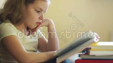 一个女学生坐在桌子旁看书。 家庭教育。 儿童教育。 知识日