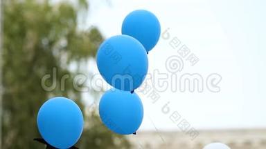 快乐的毕业生们在放气球前拿着气球，学生们的传统