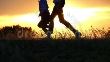 两个孩子在夕阳背景下奔跑的脚部剪影。