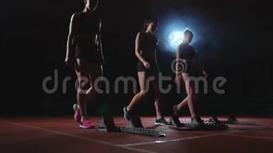 年轻的女跑步运动员带着智能手表准备在跑道<strong>起跑线</strong>上冲刺