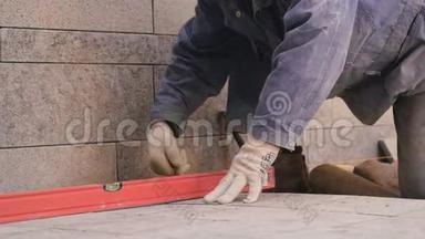 建筑工人把瓷砖放在地板上，把锤子敲在上面