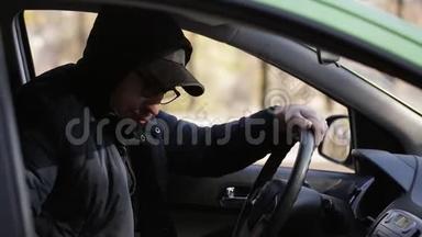 年轻的私家侦探坐在车里用<strong>单反相机</strong>拍照