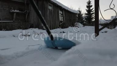 男人正在打扫房子附近的雪。 慢速视频