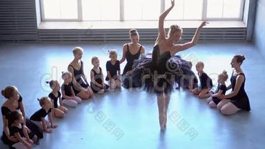芭蕾舞学校的女舞蹈演员学会跳舞。 穿着黑色舞服训练的芭蕾舞女。 孩子们`芭蕾
