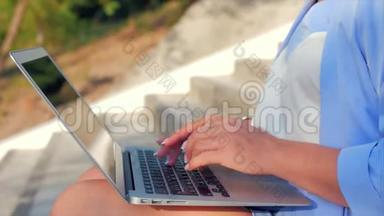 商务女士在笔记本电脑上工作，漂亮的黑发女郎穿着蓝色西装，带着笔记本电脑，漂亮的女人在她的电脑上工作